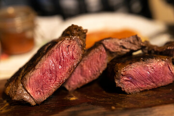 Cut Grilled Beef Steaks on Wooden Plate