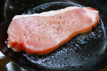 フライパンに油を引いて、ポークステーキを焼く