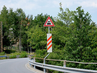 Road signs near a railway line that crosses the carriageway