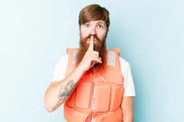 Young caucasian man wearing life jacket isolated on blue background keeping a secret or asking for...