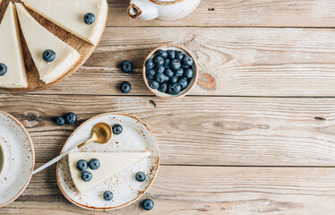Cheesecake with blueberries on white plate. Classical New York cheesecake. Wooden background