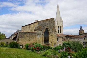 Fototapeta premium facade of an old stone house with arch window next to a church by a park in brittany france