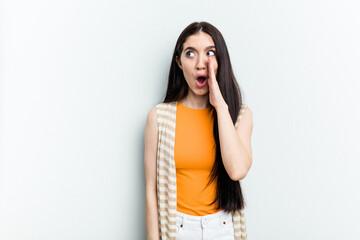 Young caucasian woman isolated on white background is saying a secret hot braking news and looking aside