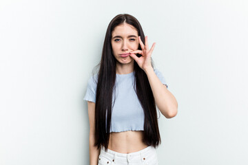 Young caucasian woman isolated on white background with fingers on lips keeping a secret.