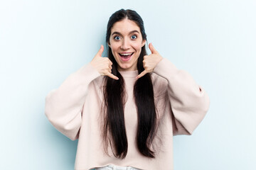 Young caucasian woman isolated on blue background showing a mobile phone call gesture with fingers.