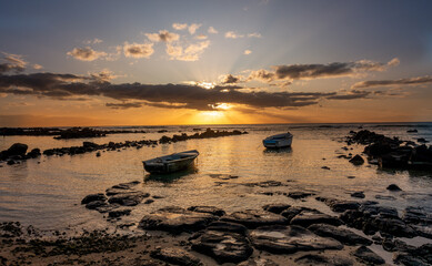 Sunset at Mauritius Pointe aux Biches beach with boats in foreground