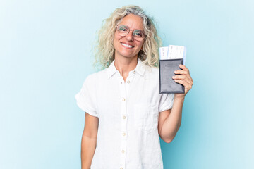 Middle age caucasian woman holding a passport isolated on white background happy, smiling and cheerful.