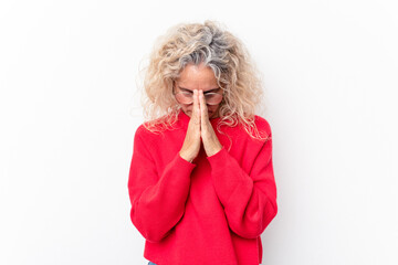 Middle age caucasian woman isolated on white background praying, showing devotion, religious person...