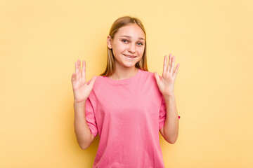 Young caucasian girl isolated on yellow background laughs out loudly keeping hand on chest.