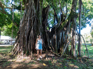Woman standing in front of a tree in the botanic garden of Mauritius, Pamplemousses