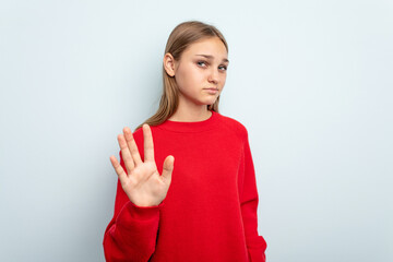 Young caucasian girl isolated on blue background rejecting someone showing a gesture of disgust.