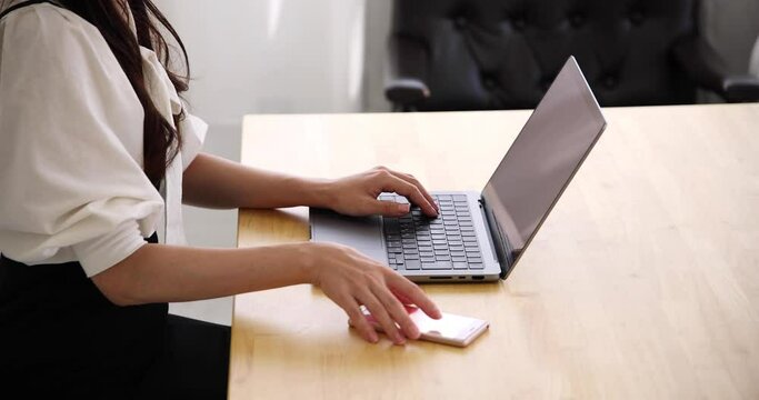 A Japanese woman checking smartphone in the home office faceless composition