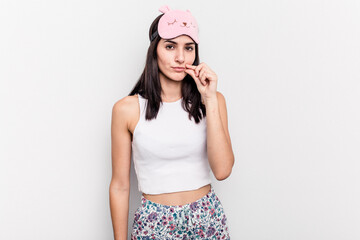 Young caucasian woman wearing a pajama isolated on white background with fingers on lips keeping a secret.