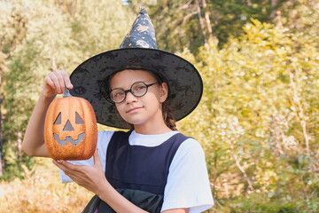 teen girl in a witch costume in the park