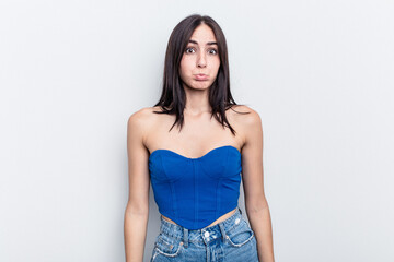 Fototapeta premium Young caucasian woman isolated on white background blows cheeks, has tired expression. Facial expression concept.