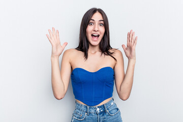 Young caucasian woman isolated on white background celebrating a victory or success, he is surprised and shocked.