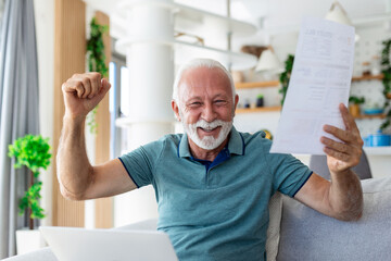 Surprised laughing happy old mature retired man looking through paper document, feeling excited analyzing financial information, getting taxes refund or bank loan approval at home.