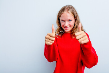 Caucasian teen girl isolated on blue background smiling and raising thumb up