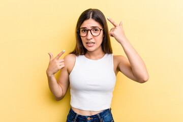 Young caucasian woman isolated on yellow background showing a disappointment gesture with forefinger.