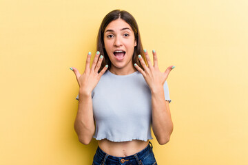 Young caucasian woman isolated on yellow background showing number ten with hands.