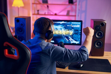 Nice gaming chair. Online streamer playing FPS shooter at home © standret