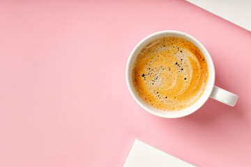 Cappuccino in coffee cup on pink background. Espresso, ristretto drink with foam. Top view, copy space