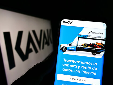 Stuttgart, Germany - 07-31-2022: Person holding smartphone with website of Mexican automotive e-commerce company Kavak on screen with logo. Focus on center of phone display.