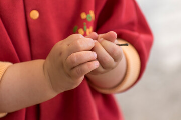 close up of a baby's hands playing with a twig, outside activity, fine motor skills development