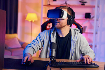 Portrait of gamer in VR glasses that playing game and streaming it online