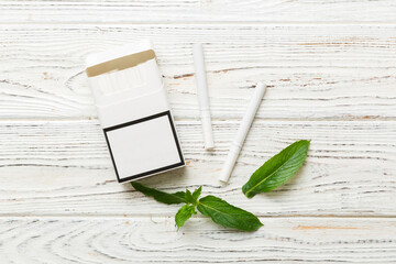 Pack of menthol cigarettes and fresh mint on colored table, Menthol cigarettes top view flat lay