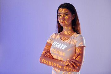 With woman word. Beautiful young woman is in projector neon lights in the studio