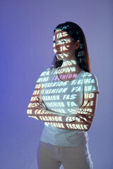 Conception of fashion. Beautiful young woman is in projector neon lights in the studio