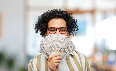 finance, currency and people concept - happy man holding hundreds of dollar money banknotes over...