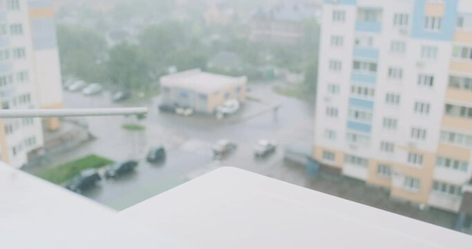 Downpour, rain. View from window of an apartment building. Drops fall on the drainage system, splashes. Outdoor air conditioner unit