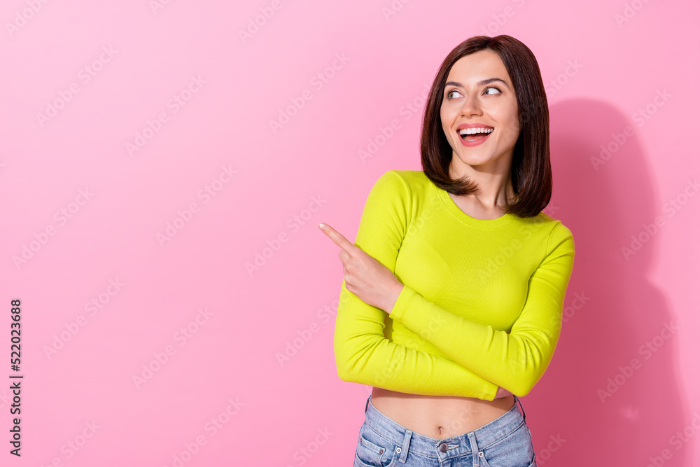 Wall mural photo of cheerful gorgeous girl look direct finger empty space blank isolated on pink color backgrou