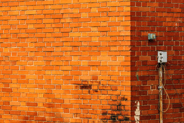 Industrial building brick wall with electric wires and switches at the outside