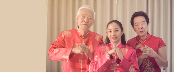 Asian family gathering Chinese New Year celebration in red traditional costume greeting