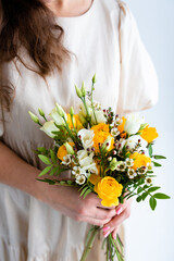  Beautiful woman with spring yellow bouquet of flowers spring and beauty concept