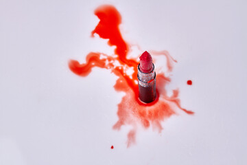 Top view red lipstick with water droplets. Red stains on white background.