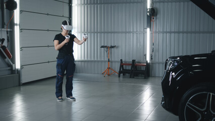 Woman asian mechanic in uniform and in modern virtual reality headset with controllers moving her...