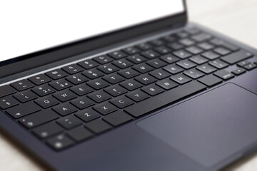 Modern, slim, backlit laptop membrane keyboard. Black keyboard large board. Selective focus.