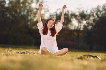 Young girls is enjoying the music. On the field at sunny daytime having nice weekend