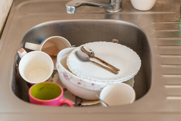 A lot of dirty dishes in the sink.Not washed dishes in the sink.Dishwashing liquid concept.