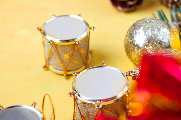 Small toys for the Christmas tree are scattered on the table - drums and ball