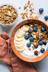 Yogurt granola bowl with blueberries, banana and chocolate. Top view