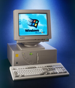 Nineties obsolete tower pc computer and Windows 95 logo on scree
