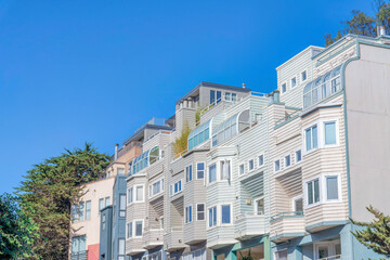 Fototapeta na wymiar Townhouses with wood lap sidings and curved glass roof below the roof deck in San Francisco, CA