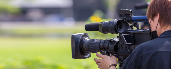 Video camera operator working with his equipment. video cinema production. Covering an event with a...