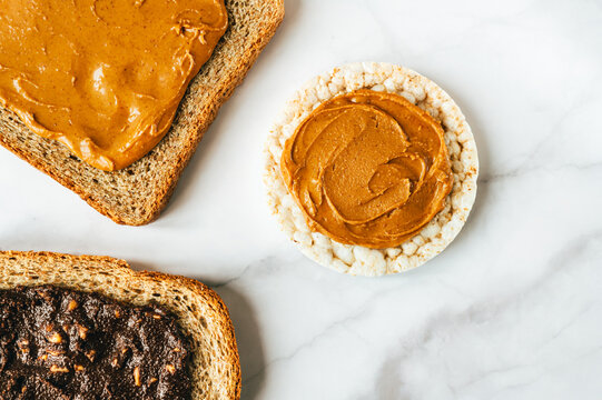 Various kind of bread, such as wholegrain, rice crakers, crispbreads and different nut butter, such as peanut, crunchy cashew and almond butter