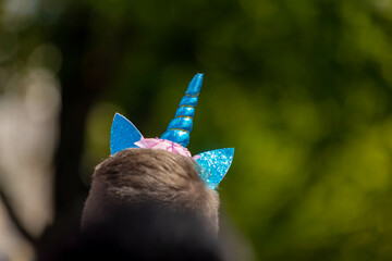 Colour of gay pride with a man wearing headband with blue unicorn horn with green background,...